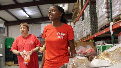 Contina Woods, foreground, is dedicated to using her success to help others succeed. Here, she is photographed volunteering at Prodisee Pantry in Spanish Fort, Ala., near Mobile. (Photo: Business Wire)