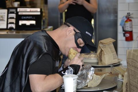 Bruce Wayne of Tiffin, Ohio enjoys his 426th consecutive Chipotle meal. To celebrate, Chipotle presented Wayne with his own Chipotle-inspired superhero gear, complete with a cape and mask. (Photo: Business Wire)