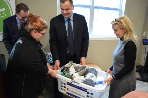 New Parkridge resident Tiffany LeBlanc receives a “welcome basket” from (L-R) Dennis Mouras, CEO, UnitedHealthcare Community Plan of Michigan and U.S. Congresswoman Debbie Dingell (MI-12); in background, Zachary Fosler, executive director, Ypsilanti Housing Commission. UnitedHealthcare, which is the largest investor in New Parkridge, donated welcome baskets filled with household items and healthy foods to each new resident (Photo: Nick Azzaro).