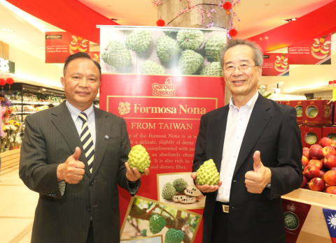 Council of Agriculture Minister Lin Tsung-hsien (left) and Mitagri Co. Chairman Chen Yu-jan both holding an atemoya pose for photos during a visit to a local supermarket as part of a business trip to Malaysia on Friday. Lin and Chen were in Kuala Lumpur to promote Taiwan-produced atemoyas as well as to gain a deeper understanding of the sales facts of imported fruits from Taiwan in Malaysia. (Photo: Business Wire)