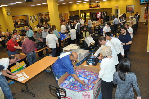 Harris Corporation employees in Clifton, New Jersey, help assemble food packs as part of a company-s ... 