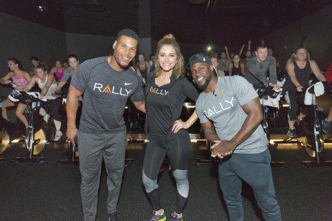 Due to inclement weather forcing the cancellation of Rally HealthFest planned in Chicago's Maggie Daley Park, Rally Health Ambassadors Kevin Hart and Maria Menounos dropped into Midtown Athletic Club for a pop-up workout. Here, (from right to left) Kevin Hart, Maria Menounos and Kevin's trainer Ron "Boss" Everline surprise spin class participants at a Chicago gym. (Photo: Business Wire)