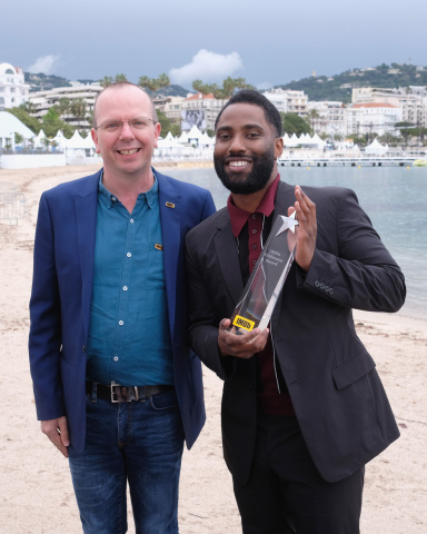 John David Washington (pictured with IMDb Founder and CEO Col Needham) receives the IMDb STARmeter Award in the Breakout category at the 71st Annual Cannes Film Festival. Photo by Getty Images for IMDb.