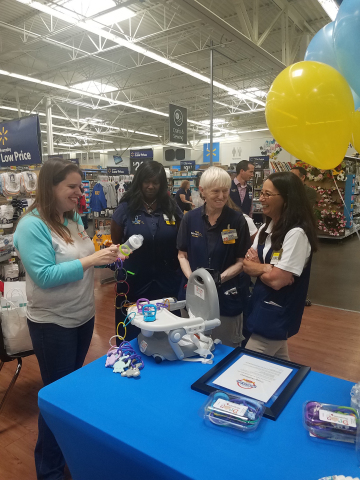 JoyLynn Waganer of St. Peters, MO-based The Drop Stoppers talks with Walmart associates following surprise announcement. (Photo: Business Wire)