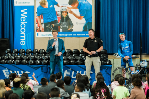 UnitedHealthcare CEO Steve Nelson (left) joins Sacramento Sheriff's Deputy Joe Gordon (center) and UnitedHealthcare Pro Cycling team member Luke Keough (right) to give third-grade students at Howe Avenue Elementary School new helmets and discuss bike safety and healthy lifestyles during a National Bicycle Safety Month event in Sacramento ahead of the final stage of the Amgen Tour of California (Photo: Shannon Rosan).