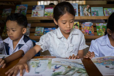 A student reads a local language children's book in the new Room to Read library at Banlech Prasat Primary School, Prey Veng Province, Cambodia. (Photo: Business Wire)