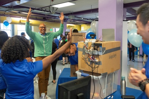 Intel employee Kevin Davenport shows his excitement as interns Azana Walker, Jonathan Bocanegra and Alston Chan demonstrate their project Trash Sort, a trash recycling system. On completion of their six-week paid internships, 37 interns from Oakland Technical and McClymonds high schools presented projects, many incorporating Intel Corporation technology, to their families, schools and communities during a presentation in Oakland, Calif., on Thursday, July 26, 2018. (Credit: Intel Corporation)