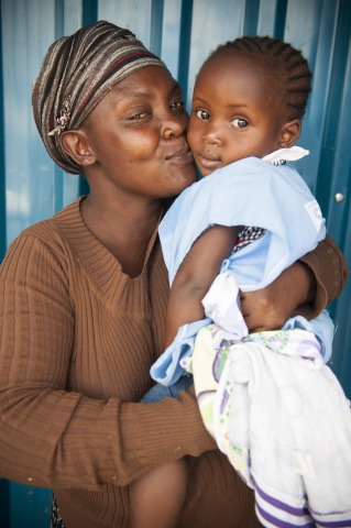 SHOFCO beneficiary Jester Aoko dropping her daughter Stephanie Angel off to begin ECD at SHOFCO.Photo courtesy of Joop Rubens/SHOFCO.
