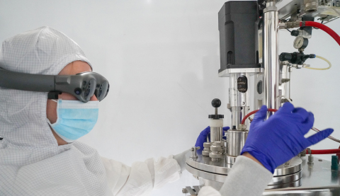 In a cleanroom gown, a lab technician uses Apprentice's conversational UI for a fully immersive AR e ... 