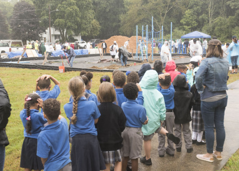 Scholars from Blackstone Valley Prep Elementary School 3 watch as volunteers from UnitedHealthcare and members of the Cumberland community build a new playground with nonprofit KaBOOM! and the New England Patriots (Photo: Alan Grant).