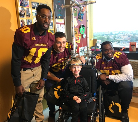 The Concordia Stingers players visited children hospitalized at Shriners Hospitals for Children - Canada after the press conference. From left to right: Jersey Henry, Concordia Stingers #10; Brandon Pacheco, Concordia Stingers #52, patient Garron, age 5, and Maurice Simba, Concordia Stingers # 78. (Photo: Business Wire)