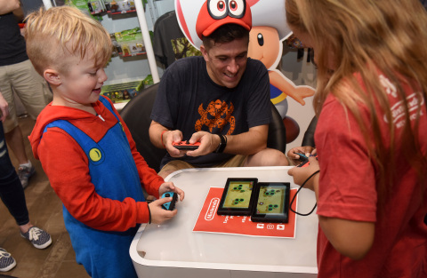 In this photo provided by Nintendo of America, Parker G., 7, Bill V. and Ava T., 8, left to right, of Rotterdam, NY, gather at the Nintendo NY store in Rockefeller Plaza to celebrate the launch of the Super Mario Party game by playing the new Toad’s Rec Room mode using two Nintendo Switch systems. An action-packed party game with 80 interactive mini-games, Super Mario Party is now available for the Nintendo Switch system. (Photo: Business Wire)