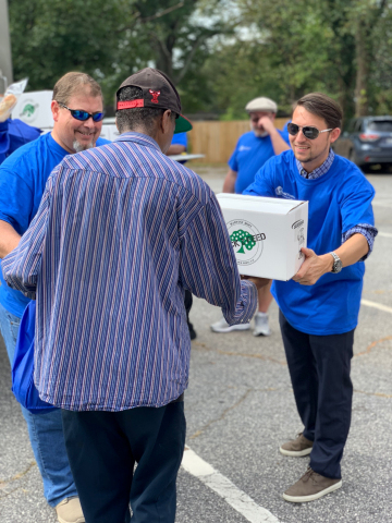 World Finance volunteers Jeff Baker (left) and Dave Dean (right) help distribute food at a mobile food pantry offered through Harvest Hope Food Bank near Greenville, SC. World Finance donated $75,000 on World Food Day, October 16, 2018, and hosted mobile food pantries in conjunction with three Feeding America affiliates across the US. (Photo: Business Wire)