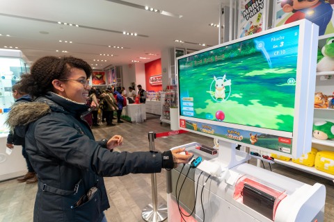 In this photo provided by Nintendo of America, Heather M. of Brooklyn, NY enjoys the immersive Poké Ball Plus accessory that can be used to play the Pokémon: Let's Go, Pikachu! and Pokémon: Let's Go, Eevee! games, now available exclusively for the Nintendo Switch system, at the midnight launch celebration at the Nintendo NY store. The games, along with the Poké Ball Plus accessory, each launched exclusively for the Nintendo Switch system on Nov. 16, 2018. (Photo: Business Wire)