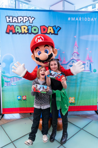 In this photo provided by Nintendo of America, Lucia M., 11, and Adrian M., 8, celebrate Mario Day (MAR10) at the Nintendo NY store in Rockefeller Plaza with everyone’s favorite video game hero, Mario. (Photo: Business Wire)
