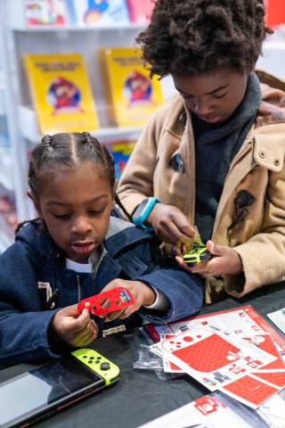 In this photo provided by Nintendo of America, Avery D., 7, and Quinn D., 4, celebrate Mario Day (MAR10) during a special event at the Nintendo NY store in Rockefeller Plaza with Mushroom Kingdom-themed activities and decals for personalizing their Nintendo Switch system. (Photo: Business Wire)
