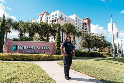 Hilton Team Member Serby Castro stands in front of the Embassy Suites by Hilton property in Orlando where she collects leftover hygiene products to donate to countries in need. (Photo: Hilton)