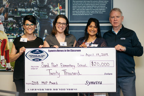 Symetra and the Seattle Seahawks awarded Sand Point Elementary School in Seattle with the 2018 Symetra Heroes in the Classroom® “MVP Award.” The $20,000 grant will fund an innovative student achievement program—“Hear Our Voices”— focused on providing a platform for Sand Point Elementary’s fourth- and fifth-grade students to share stories by recording and producing oral histories. (Pictured left to right: Zoe Manzo, 2018 Symetra Heroes in the Classroom honoree and Sand Point Elementary School teacher; Kristen Roberts, principal, Sand Point Elementary School; Sharmila Swenson, AVP, Public Affairs, Symetra; Mike Flood, VP, Community Outreach, Seattle Seahawks.) (Photo: Business Wire)