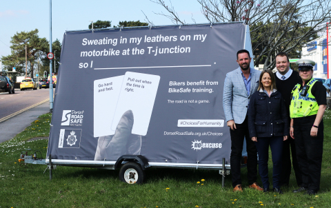 (R to L) Daniel Smith, CEO of Fireworx, pictured next to one of the mobile advertising boards with Laressa Robinson, Dorset Road Safety Education Manager; Kristian Ward, Communications Officer at Devon and Cornwall Police & Dorset Police and PC Heidi Moxam, Road Casualty Reduction Officer (Photo: Business Wire)