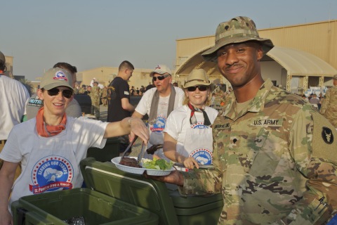 Spc. Theoo Cameron-Williams, a member of the Minnesota National Guard’s 34th Red Bull Infantry Division, is served a special steak dinner at Camp Arifjan, Kuwait by volunteers from Minnesota-based Serving Our Troops. This meal marks the 100,000th steak served by the volunteer group since the program began in 2004. Spc. Cameron-Williams is from Minneapolis, Minn. Photo by Michael Murray
