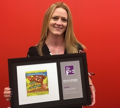 PAC Canadian Leadership Awards Silver Winner in New Brand Food & Beverage: Jeanine Gingrich, buyer Dare Foods, with image of Pawley Bear and the Silver award given to ProAmpac for packaging My First Bear Paws Vanilla and My First Bear Paws Oatmeal, the new healthy-alternative snack cookies from Dare Foods Ltd. (Photo: Business Wire)