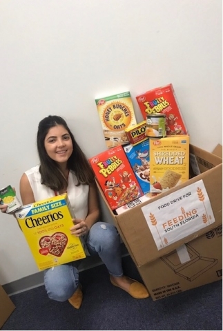 Melanie Da Silva shows some of the items donated by team members from PGT Innovations’ Hialeah facility to Feeding South Florida in Pembroke Park, Florida (Photo: Business Wire)