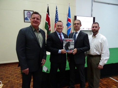 Caliburn presents a copy of one of 12 U.S.-developed training manuals to Larry Swift (U.S. Department of State) and Alexander Riebl (UNMAS). Pictured from left to right: Phillip Ayrton, Munitions and Environmental Remediation Project Manager (Caliburn); Larry Swift, Training Program Manager (contractor with U.S. Department of State); Alex Riebel, IED Threat Mitigation Advisor (UNMAS); David Courtney, Munitions and Environmental Remediation International Operations Program Manager (Caliburn). (Photo: Business Wire)