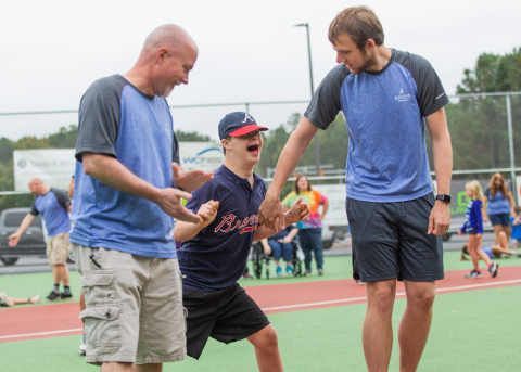 Ascend Cares volunteers help a Miracle League player round the bases on their new field. (Photo: Business Wire)