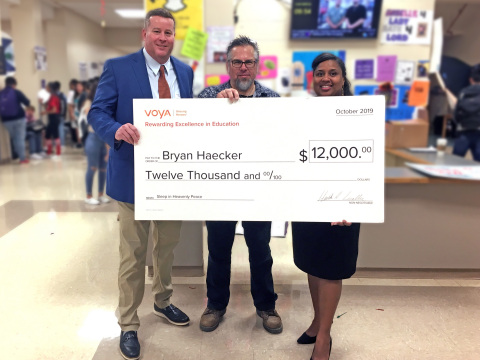 San Antonio, Texas teacher Bryan Haecker from Earl Warren H.S. (pictured in middle) is awarded a grant for $12,000 as the second place winner of Voya’s Unsung Heroes program. David Bowman, regional vice president, Voya Financial (pictured on left) presented the check to Mr. Haecker, alongside Valerie Sisk, principal of Earl Warren H.S. (pictured on right).