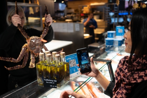 A Chinese tourist uses Alipay to pay for items at a store in Norway. (Photo: Business Wire)