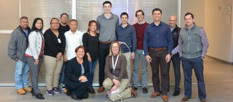 Adam Millar (center, wearing gray shirt) is pictured with Abiomed employees who helped make his Impella heart pumps. Adam was 18 when he received an Impella CP and RP. Initially, physicians considered Adam a candidate for a costly implantable LVAD and heart transplant, but they were not needed after Impella helped recover his native heart. (Photo: Business Wire)