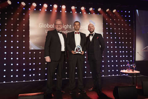 Genesee Wyoming UK/Europe Region Intermodal Commercial Director Clive Slayford (center) accepts Freightliner's award for Rail Freight Operator of the Year at the 2019 Global Freight Awards, flanked by Peter Livey (left), MD of category sponsors HMM, and comedian Tom Allen, host (right). (Photo: Business Wire)