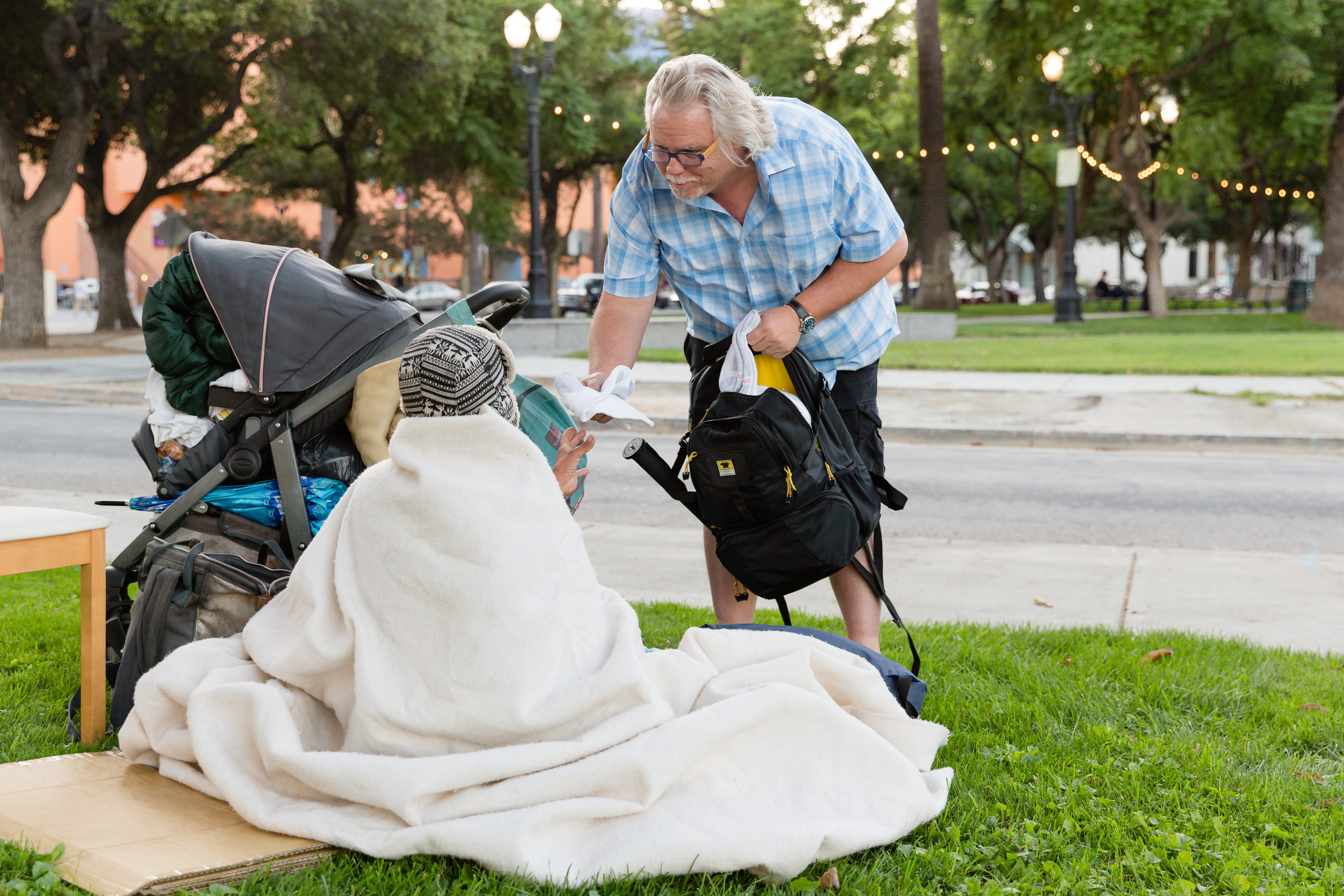 Rich man buys homeless man. Help to homeless. A woman helping a homeless man. Invisible people Mark Hovath poverty.