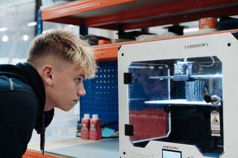 14-year-old Harris Gribble watches an Open Bionics Hero Arm being produced in a 3D printer (Photo: Business Wire)