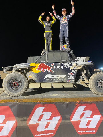 Kurtis Elliot (left) and Mitch Guthrie Jr. (right) standing atop the 2019 Turbo S of Mitch Guthrie Jr. on the podium after winning the 2020 Baja Designs UTV Night Race at the King Shocks Laughlin Desert Classic. (Photo: Best In The Desert)