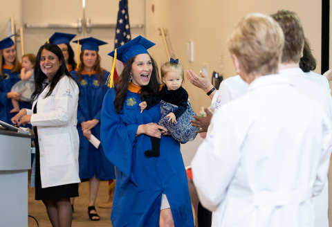 A student at the Hofstra Northwell School of Nursing and Physician Assistant Studies proudly brings her daughter to commencement. Hofstra and Northwell will begin offering an undergraduate nursing program in 2021. Credit Hofstra University.