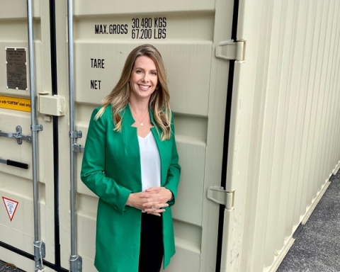 Amy Thompson, President & co-Founder of Northern Container Sales, stands in front of a shipping container. (Photo: Business Wire)