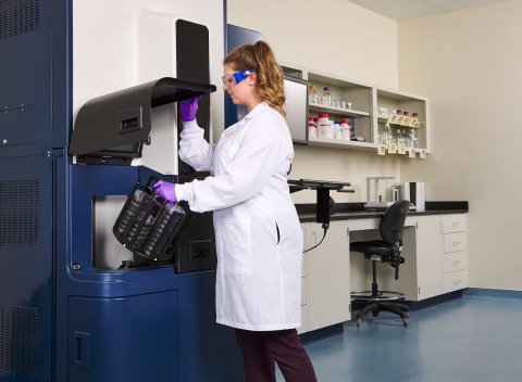 A quality control specialist loads multiple sample cartridges into the Rapid Micro Biosystems Growth Direct instrument for automated, high-throughput microbial contaminant testing. (Photo: Business Wire)