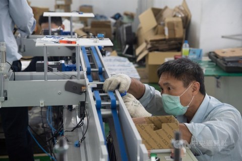 A technician is seen inspecting a face mask machine at a machine tool manufacturing plant in New Taipei. CNA photo March 21, 2020