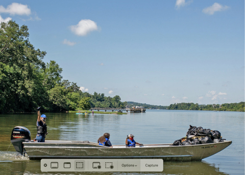 Kathleen Gibi, Executive Director, Keep the Tennessee River Beautiful, and volunteers use a Yamaha V MAX SHO-powered work boat to remove trash and debris from the Tennessee River. (Photo: Business Wire)