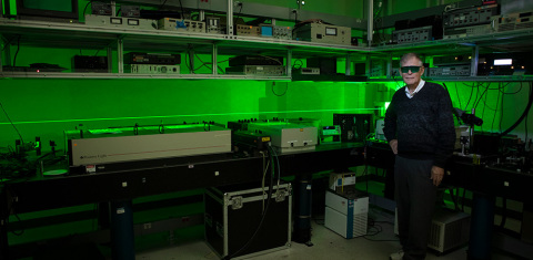 original “The image is a diode-laser pumped Verdi 5W green laser manufactured by Coherent,” notes Byer. “The Nd:YVO4 (Neodymium Yttrium Vanadate) infrared laser is frequency doubled to the green using a Lithium Borate (LBO) nonlinear crystal. The 5W of green scatters from the air in the laboratory to make the visible laser beam and is enough power to require the wearing of laser safety goggles. This green laser was designed for research as a pump laser for a tunable titanium-doped sapphire laser that is tunable in the red region of the spectrum.” (Photo Credit: Misha Bruk)