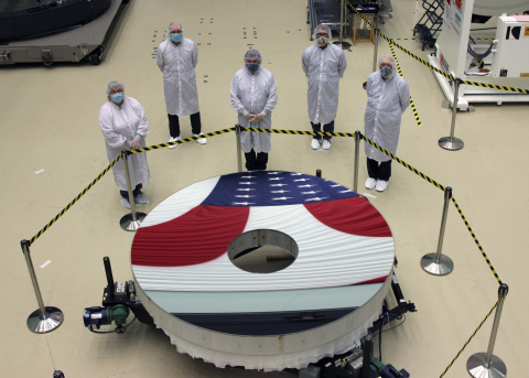 In honor of Labor Day, workers at an L3Harris Technologies (NYSE:LHX) facility in NY observe the reflection of a U.S. flag in the newly completed primary mirror for NASA’s Nancy Grace Roman Space Telescope. The nearly 8-foot ultra-high-performance mirror will enable the telescope to gaze into space from a vantage point of 930,000 miles from Earth, helping scientists discover previously unseen parts of the universe, such as exoplanets and dark energy. The mirror sports a protective silver coating that is about 200 times thinner than a human hair, is so finely polished that the average bump on its surface is only 1.2 nanometers tall and is made of specialty ultralow-expansion glass to withstand the harsh temperature extremes of space. Roman is scheduled for launch in the mid-2020s. Learn more: https://go.nasa.gov/32ZWEDx (Photo: Business Wire)