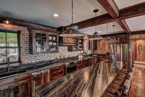 Hiawatha on Star, Sayner, WI: Wood-paneled walls, granite countertops, and wool-upholstered chairs elevate this cabin kitchen. (Photo: Business Wire)