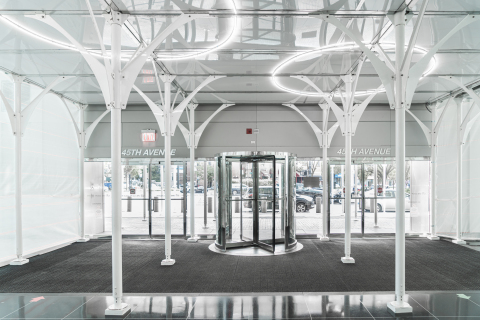 Urban Umbrella's flagship product is a revolutionary, cross-bracing-free sidewalk shed composed of high-strength steel, translucent plastic panels, LED lighting, and white arching struts that combine the strength of a highway bridge and the beauty of a work of art (Photo: Business Wire)
