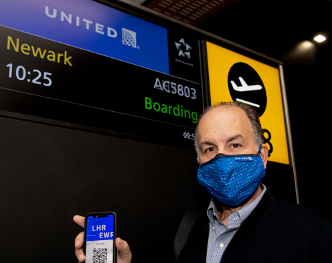 Preparing to board his flight from London to Newark, Peter Vlitas, Senior Vice President, Airline Relations, Internova Travel Group, holds up the unique QR code on the CommonPass health pass that allows travellers to securely share their COVID status across international borders while protecting privacy. (Photo: Business Wire)