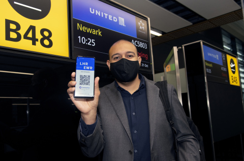 Preparing to board his flight from London to Newark, Jason Oshiokpekhai, Managing Director, Global Travel Collection, holds up the unique QR code on the CommonPass health pass that allows travellers to securely share their COVID status across international borders while protecting privacy. (Photo: Business Wire)