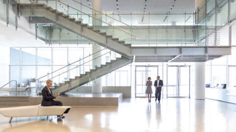 original Lobby of an office building facing the entrance with persons walking into the building. (Photo: Wells Fargo)