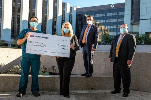 Presenting the check from Raymond James Beverly Hills office. From Left to right : Lisa Detanna, Managing Director; Larry DiGioia-Senior Vice President, Investments; Andy Waldbaum-Branch Manager.