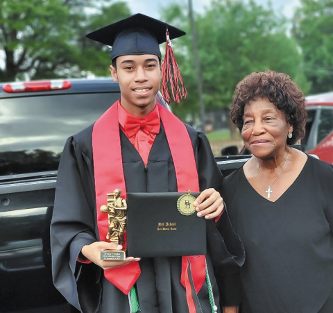 Shamar Peoples holds his high school graduation diploma next to his grandmother, who accredits HOPE Farm for their support in his success. (Photo: Business Wire)