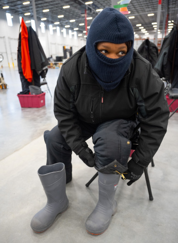 A distribution center worker in McKesson’s Olive Branch, Miss. location dresses in protective gear prior to entering the walk-in freezer to pack cooler boxes with Moderna’s COVID-19 vaccine doses. (Photo: Business Wire)